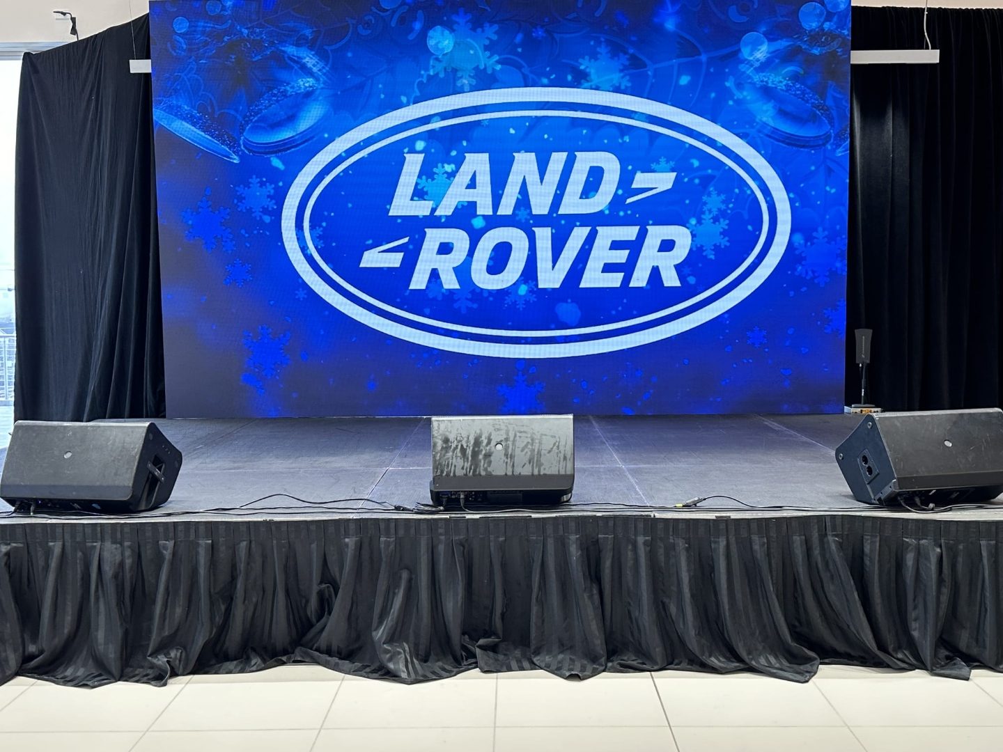 Corporate holiday event stage with a large brand video wall